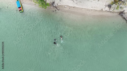 Aerial View Of People Swimming In Turquoise Water Near Tropical Beach With Colorful Boats