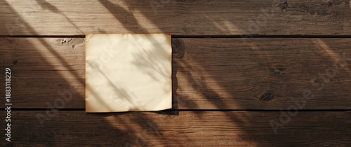 Aged wood backdrop featuring vintage blank paper and sunlight rays