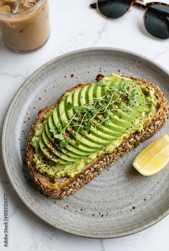 Multigrain Avocado Toast with Fan Sliced Avocado, Microgreens, Red Pepper Flakes, and Lemon Wedge