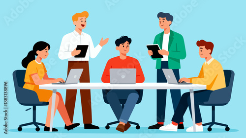 A group of people are sitting around a table with laptops and tablets. They are working together on a project