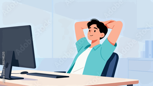 A man is sitting at a desk with a computer monitor in front of him. He is wearing a blue shirt and he is relaxed