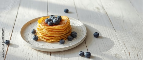 Plant-based crepes made from chickpea flour, gluten-free all-purpose flour, and oat milk, served with frozen blueberries on a white wooden table