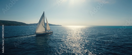 Detailed view of a sailboat underway with fully deployed sails, including mainsail and foresail under sunny skies