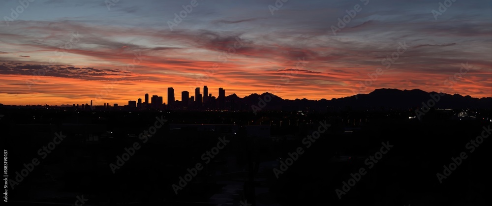 Obraz premium Breathtaking desert cityscape of Phoenix at twilight with dramatic horizon and silhouette