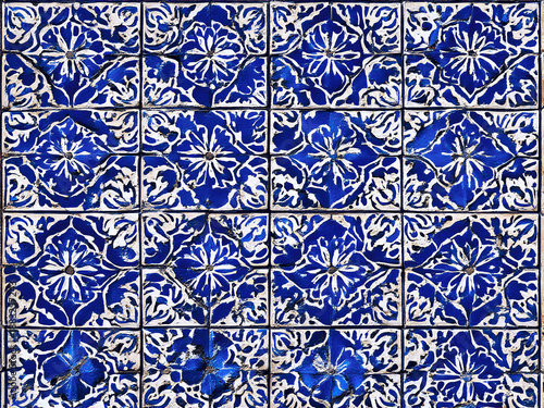 Blaue Fliesen-Grafik: Symmetrische florale und ornamentale Muster in strahlendem Blau auf weißem Grund, inspiriert von klassischen Keramikfliesen (Azulejos).KI Generiert