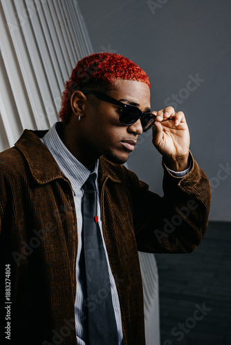 Portrait of black man holding his sunglasses with serious expression