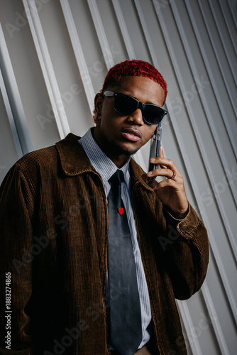 Portrait of a black man talking on the phone and looking at the camera with a serious expression