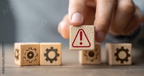 The warning block held above gear cubes symbolizing risk and system failure