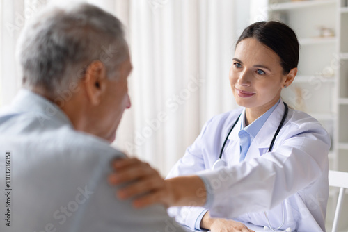 Female doctor offering emotional support to stressed senior male patient during consultation, compassionate healthcare and mental support concept