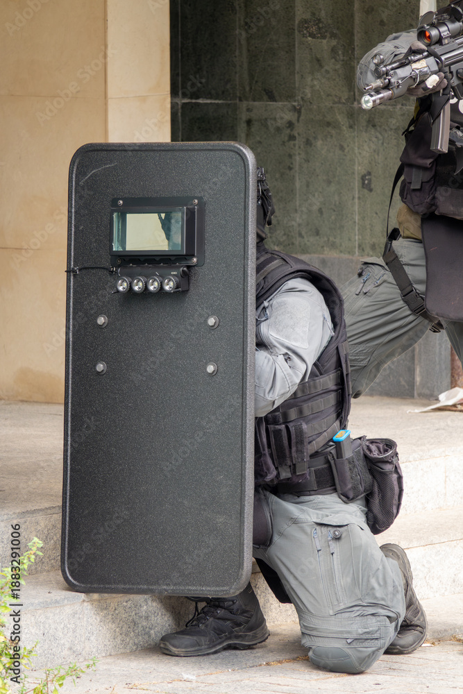 custom made wallpaper toronto digitalTactical Police Unit in Action with Ballistic Shield and Assault Rifle During Urban Operation. Armed SWAT Officers in Full Gear Performing in City Environment