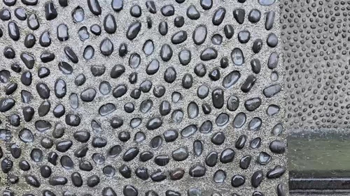 The waterfall curtain is made of artificial fiberglass rocks or small stones, adding a refreshing touch to the atmosphere.Waterfall, stream, natural rocks.A waterfall flows from above the stone wall. 