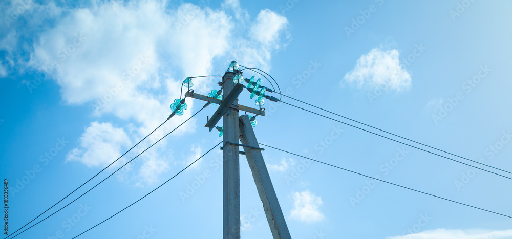 Fototapeta premium Electric cables on electric poles with a blue sky.