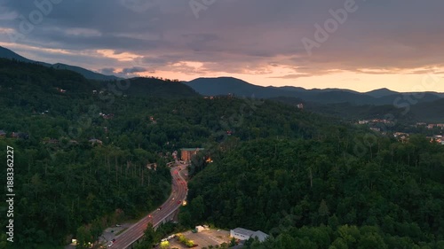 Gatlinburg main street parkway lined with illuminated restaurants, souvenir stores, and mountain lodges. Tennessee travel destination at night.