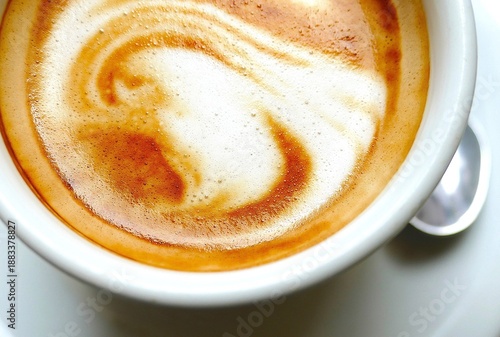 Cup of coffee with milk and tasty foam on the table in the bar, coffee background