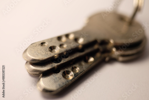 Bild auf Leinwand Macro shot of three brass high-security dimple keys on a white background, featuring shallow depth of field focusing on the drilled patterns and metallic texture