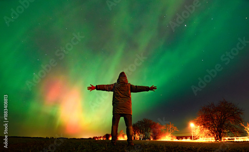 A person looking at Northern lights aurora borealis Lund Skane Sweden 19.01.2026
