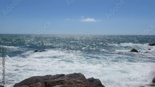 Turquoise Waves and White Sea Foam Crashing on Coastal Rocks