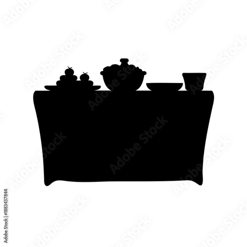 Silhouette of food and tableware on a table casting a dark shadow