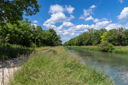 Canal path winding along a calm waterway
