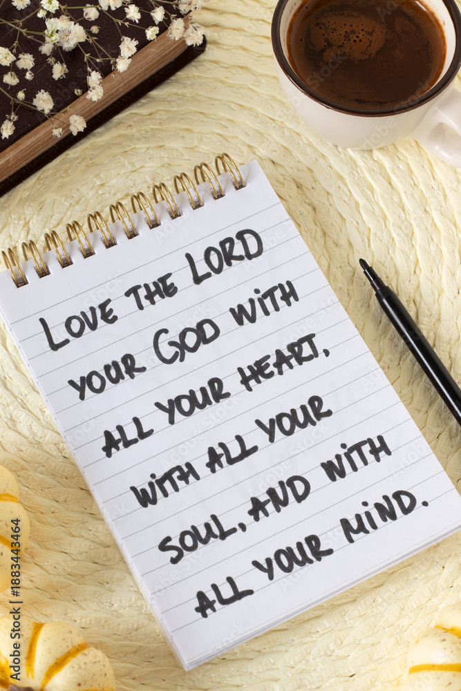 Fototapeta premium Inspirational quote to love God with all your heart in a notebook with holy bible and coffee cup. Christian obedience, wisdom, and spiritual law, biblical concept.