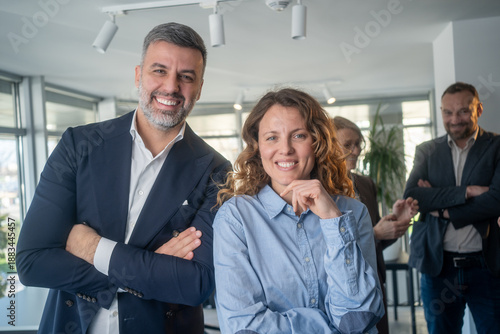 Portrait of happy multi ethnic business couple posing with arms crossed
