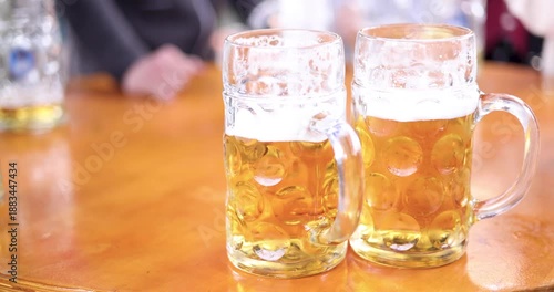Wallpaper Mural Two beer mugs on a table of a beer fair in Germany in slow motion Torontodigital.ca