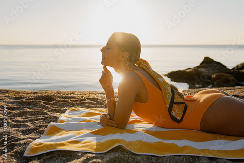 Obraz na plátně beautiful blond smiling woman lying on beach tanning sunbathing on summer season