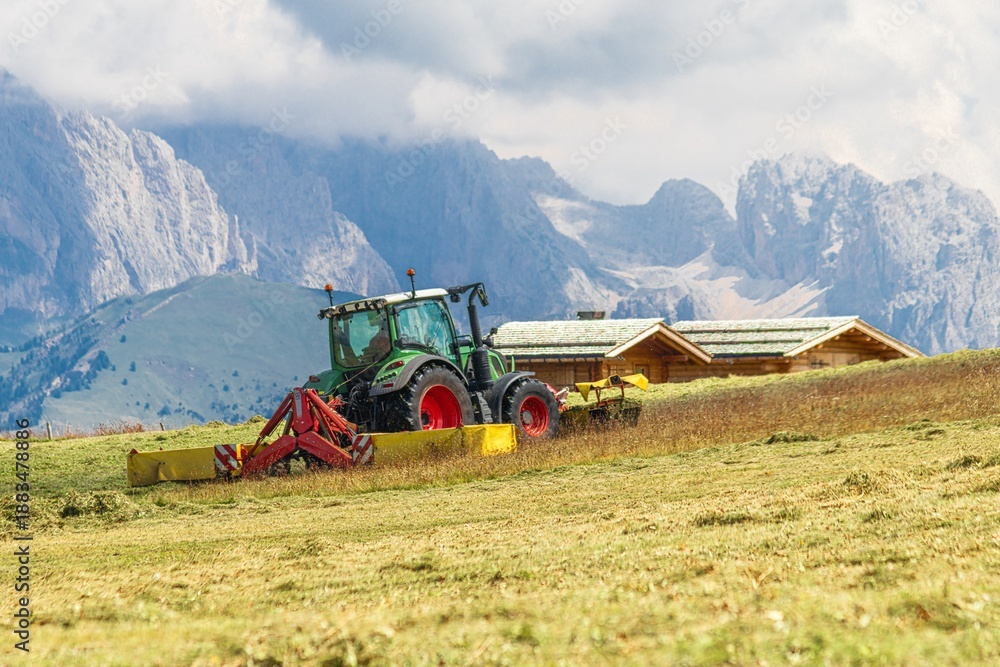 Naklejka premium Tractor with combined mower in alpine hayfield