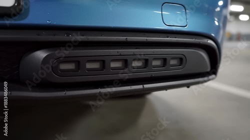 Automated car parking sensor blue vehicle bumper with green light indicator indoor parking garage showing advanced technology and safety features