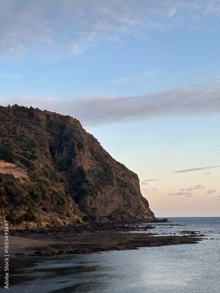 Fototapeta premium Sunset Over a Rocky Coastline by the Sea