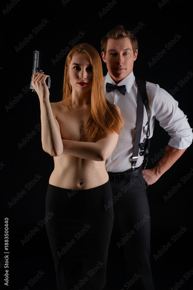 custom made wallpaper toronto digitalConfident couple poses dramatically with prop gun under dark lighting