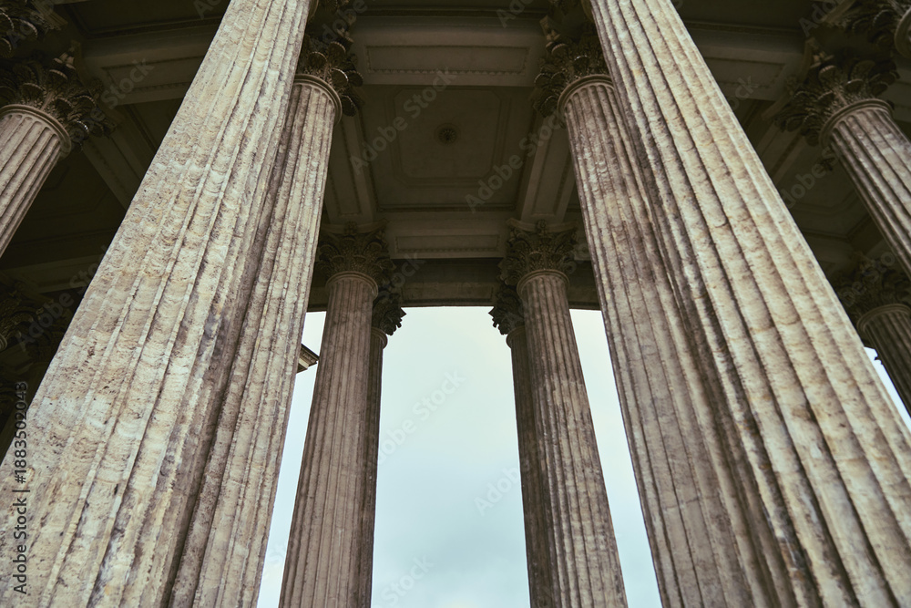 Fototapeta premium Majestic ancient colonnade viewed from ground level under overcast sky