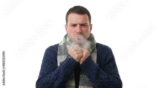 Man in winter clothes blowing on his hands to keep warm.