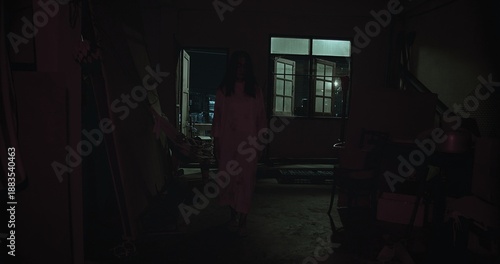 Eerie Asian ghost woman with long dark hair, wearing a pale dress, standing mysteriously in a dimly lit, old room at night, generating an unsettling feeling of supernatural horror and suspense.