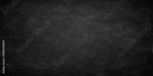 A dark textured blackboard with a grunge vintage surface and aged gray chalk board pattern creates a blank stone wall backdrop for your design
