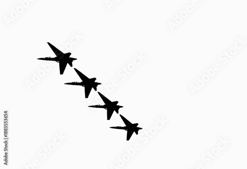 Silhouetted Formation Flight of Four Jet Fighters in Clear Sky Demonstrating Precision and Synchronization at High Altitude