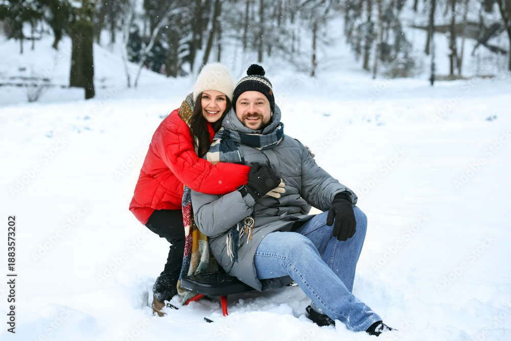 Obraz premium Happy couple with sledge outdoors on winter day