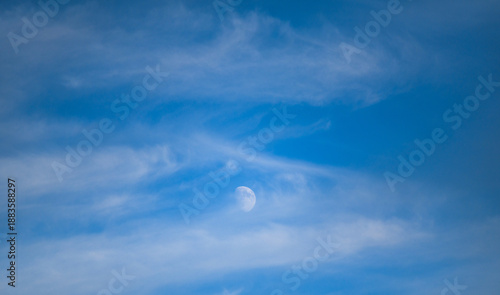 Bild auf Leinwand the moon in broad daylight behind the clouds