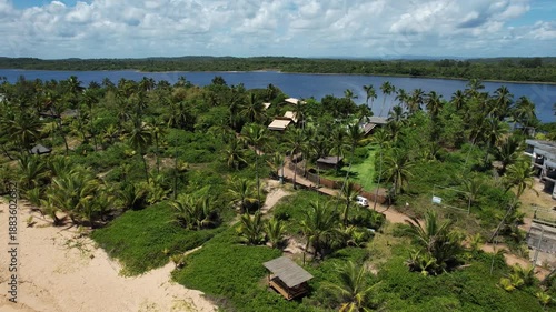 Panoramic aerial view of beaches and lagoon, with a car passing along the Bromeliad Trail, southern coast of Bahia, Maraú Peninsula, Barra Grande