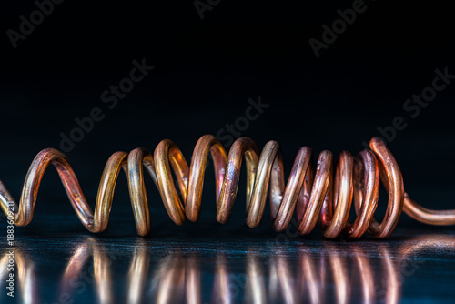Close-up of copper wire surface after thermal processing and water cooling, showing multicolored copper oxide layers typical for non ferrous metal raw materials
