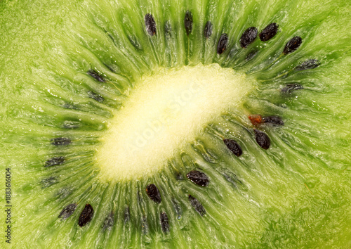 A close up of a kiwi fruit with black seeds