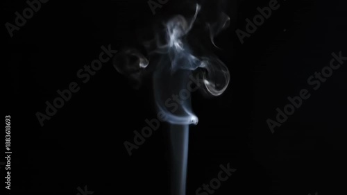 Smooth incense smoke swirls in a blue light pattern against a black background, creating an artistic wave of burning aroma and motion