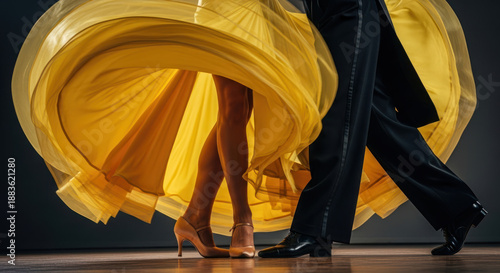 A dancer in a yellow dress performing with a partner on stage.