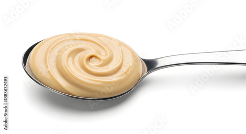 Creamy tahini on metal spoon isolated on white background, smooth texture and versatile food ingredient.
