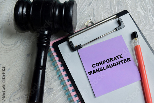 фотографія Concept of corporate manslaughter write on sticky notes isolated on Wooden Table