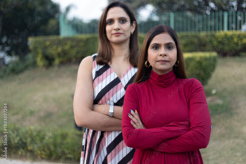 Obraz premium Two indian women arm crossed while looking at the camera at outdoor. Self independent women