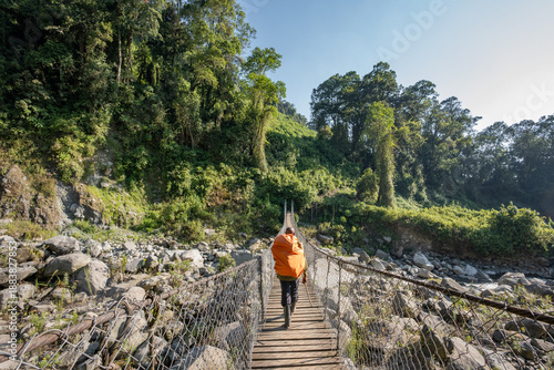 Slika na platnu Mountain guide crossing suspension bridge during a hike in Rwenzori Mountains, U