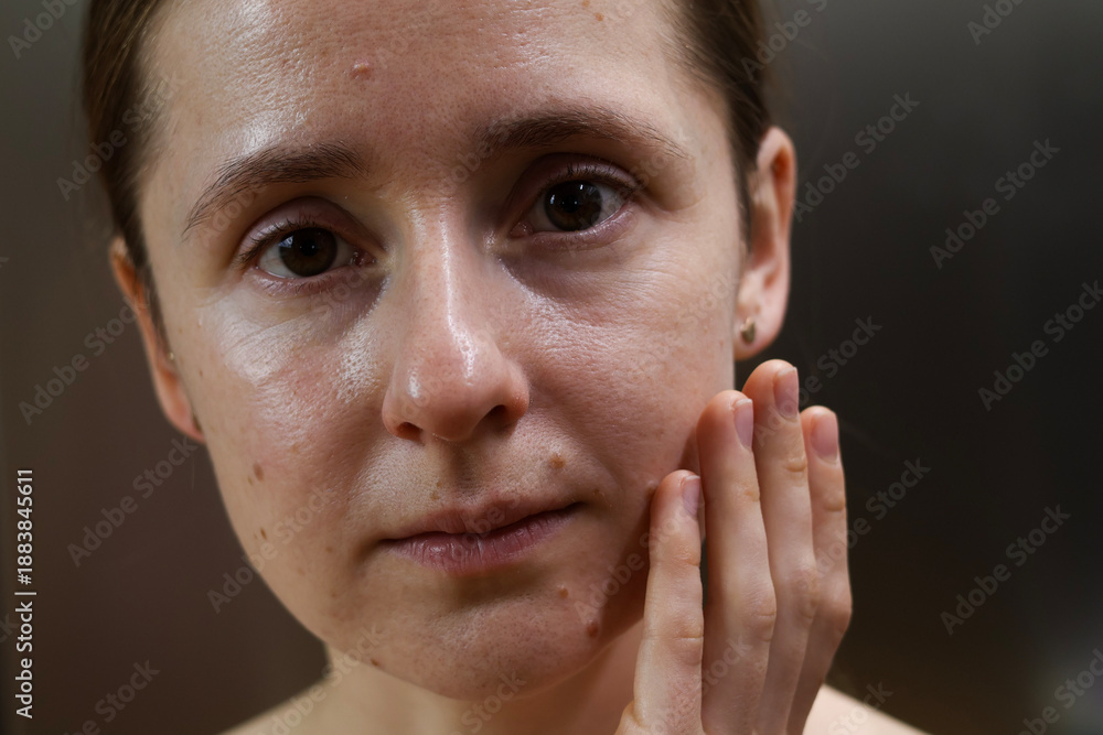 Fototapeta premium Natural portrait of a young woman with clean skin and minimal makeup, showing real facial texture and calm emotion. Authentic lifestyle beauty concept, skincare, self care, natural appearance