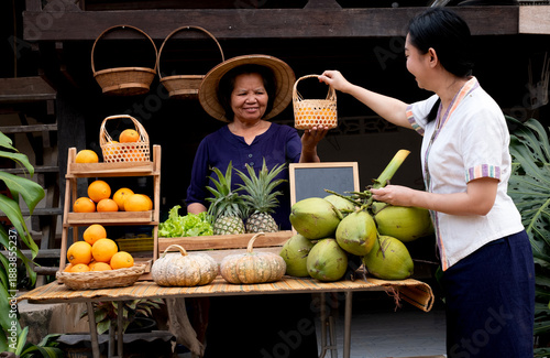 A smiling Asian woman holding a fresh grocery bag filled with fruit and vegetables while standing in front of a store  at the farm stay at Thailand
