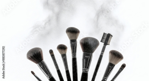 A professional set of black makeup brushes and cosmetic tools featuring a powder applicator and mascara brush isolated on a white background for fashion and beauty